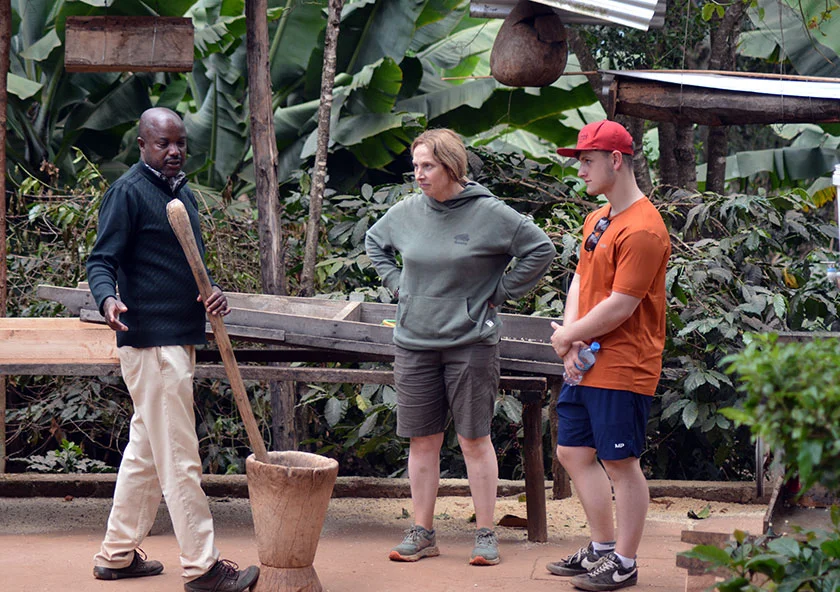 Masatu Tours guide with travellers at Chagga camp near Materuni Waterfalls Moshi Tanzania — coffee tour and 80m waterfall day trip