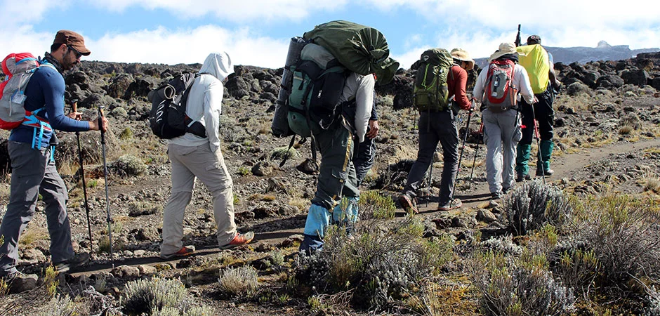 Kilimanjaro climber with porters on Machame Route Shira Plateau Tanzania — Whiskey Route 6-7 day trekking adventure