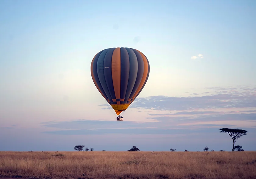 Hot air balloon over the Serengeti at dawn, the iconic image that put safari travel on screens around the world